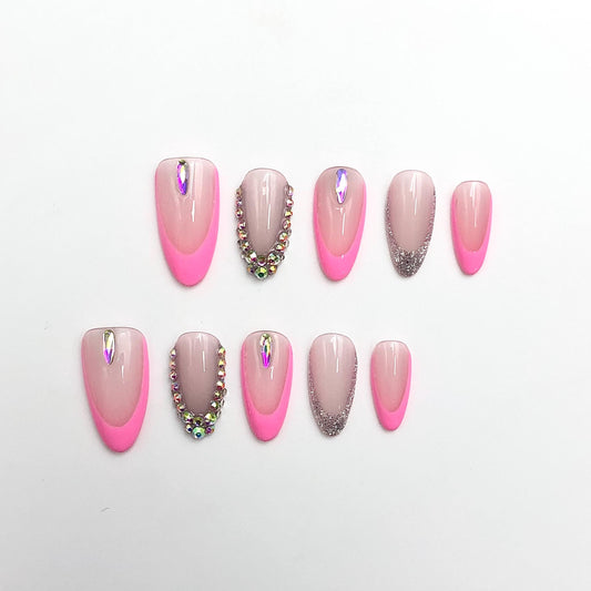 Pink French tip nails rhinestone art almond-shape press-on nude pink glitter accent glam trendy sparkly decorative fake  manicure design.