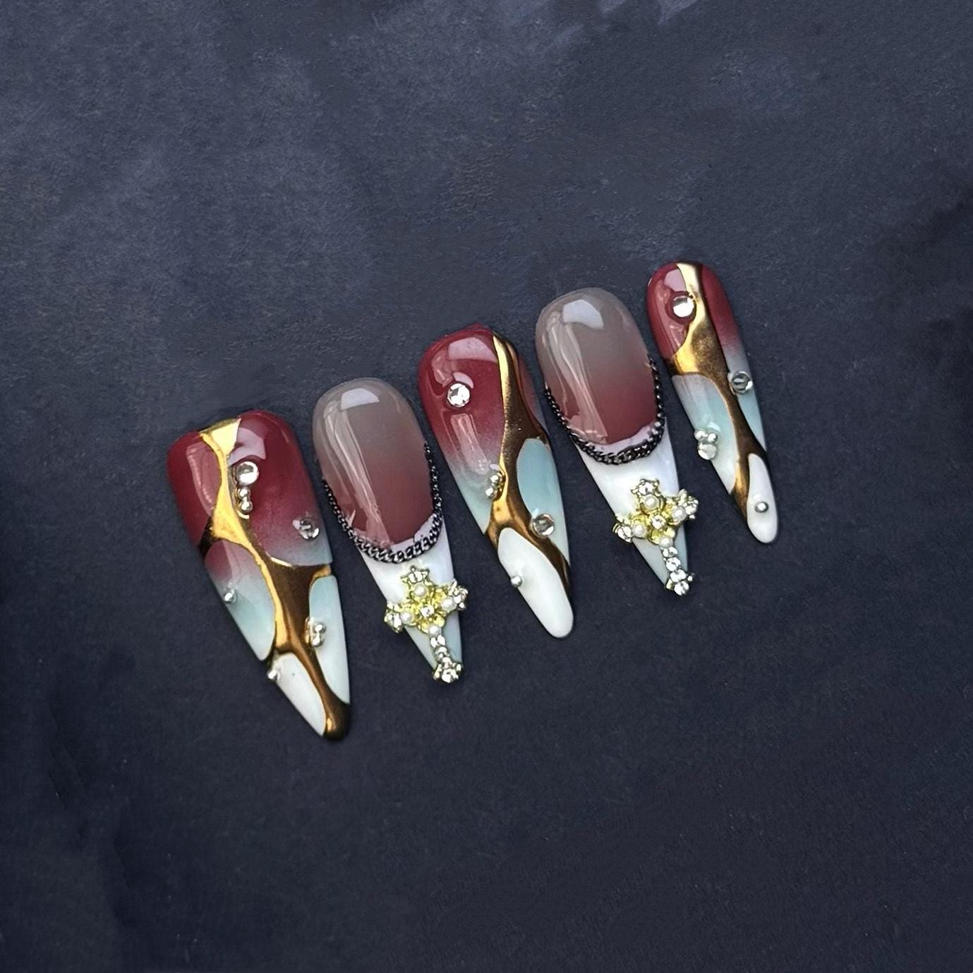 Gothic Elegance Press-On Nails with Gold Cross Charms. Burgundy and Marble Stiletto Set. Artificial reusable glue on faux nails trendy art.