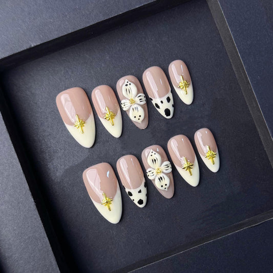Neutral Cow Print Press-On Nail with 3D Floral Accent and Gold Cross Charms. Artificial reusable fake glue on faux manicure nail trendy art.