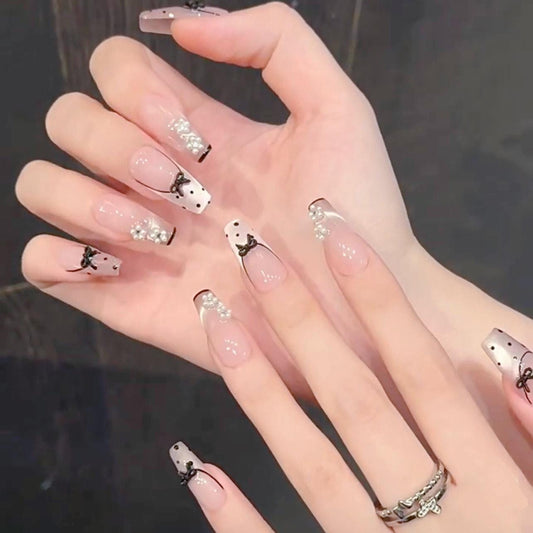 Nude Pearl Press On Nails with Black Bows Polka Dots and French Tips. Artificial reusable fake glue on faux manicure nails trendy art.