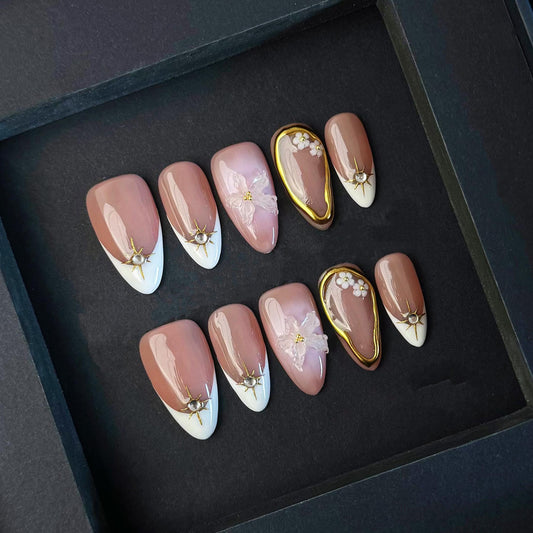 Elegant Nude Press On Nails with 3D Flower Gold Accents French Tips and Pearl Charms. Artificial fake glue on faux manicure nail trendy art.