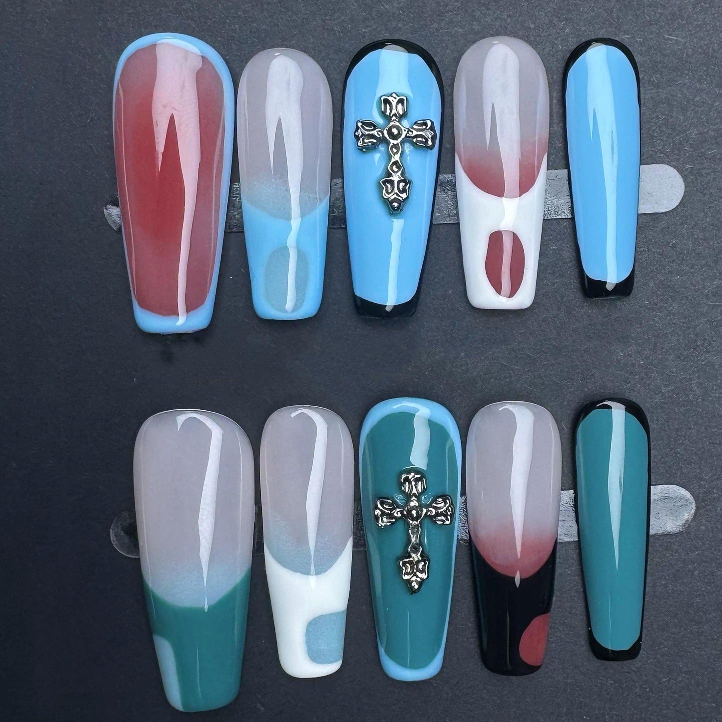 Modern Abstract Press On Nails with Cross Charm Red Teal and Sky Blue Color Blocking. Artificial fake glue on faux manicure nail trendy art.
