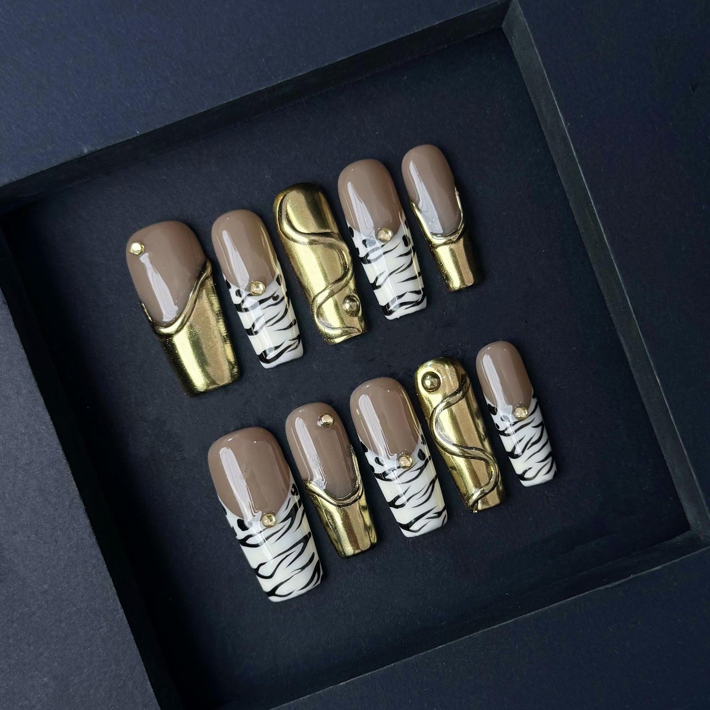 Gold Chrome and Zebra Stripe Press On Nails with Nude Base and Stud Accents. Artificial reusable fake glue on faux manicure nails trendy art