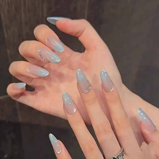 Icy Blue Cat Eye Press On Nails with Silver Gradient Tips and Rhinestone Accents. Artificial reusable glue on faux manicure nail trendy art.