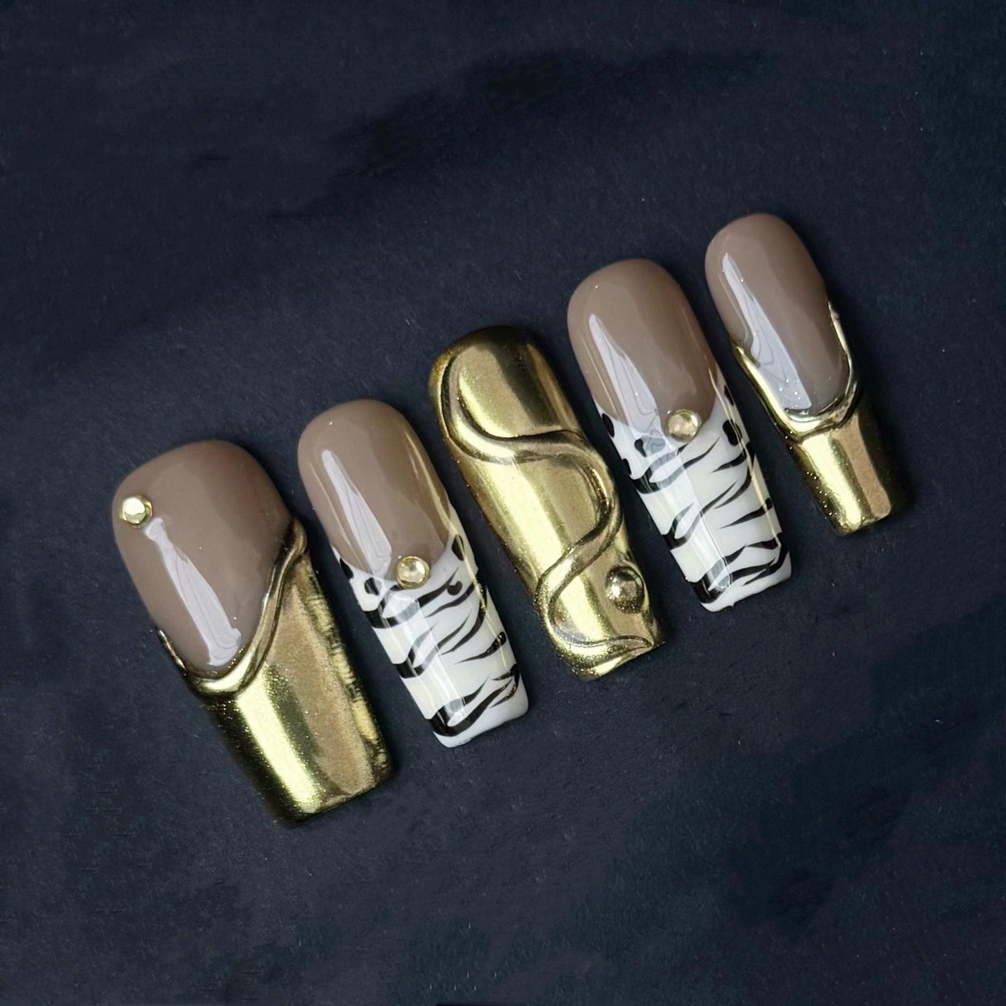 Gold Chrome and Zebra Stripe Press On Nails with Nude Base and Stud Accents. Artificial reusable fake glue on faux manicure nails trendy art