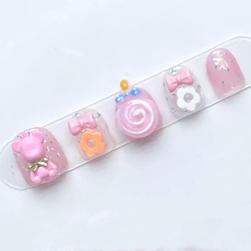 Pink Candy Bear Press On Nails for Kids with 3D Lollipop Flowers Bows and Glitter Accents. Artificial faux manicure nails trendy art.