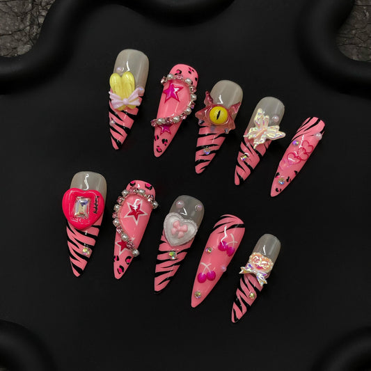 Y2K nails, pink zebra kawaii art, 3D charms, stiletto rhinestone butterfly charms heart embellishments, star bold anime-inspired girly glam