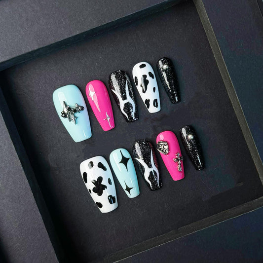 Alt Cow Print Press On Nails with Pink Chrome Stars Cross Charms and Galaxy Black. Artificial reusable fake glue on faux manicure nails art.