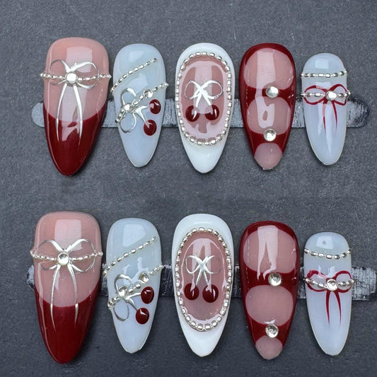 Cherry Bow Glam Nails – Red French Tips & Rhinestone Accents. Artificial reusable fake glue on faux manicure nails trendy art.