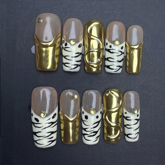 Gold Chrome and Zebra Stripe Press On Nails with Nude Base and Stud Accents. Artificial reusable fake glue on faux manicure nails trendy art